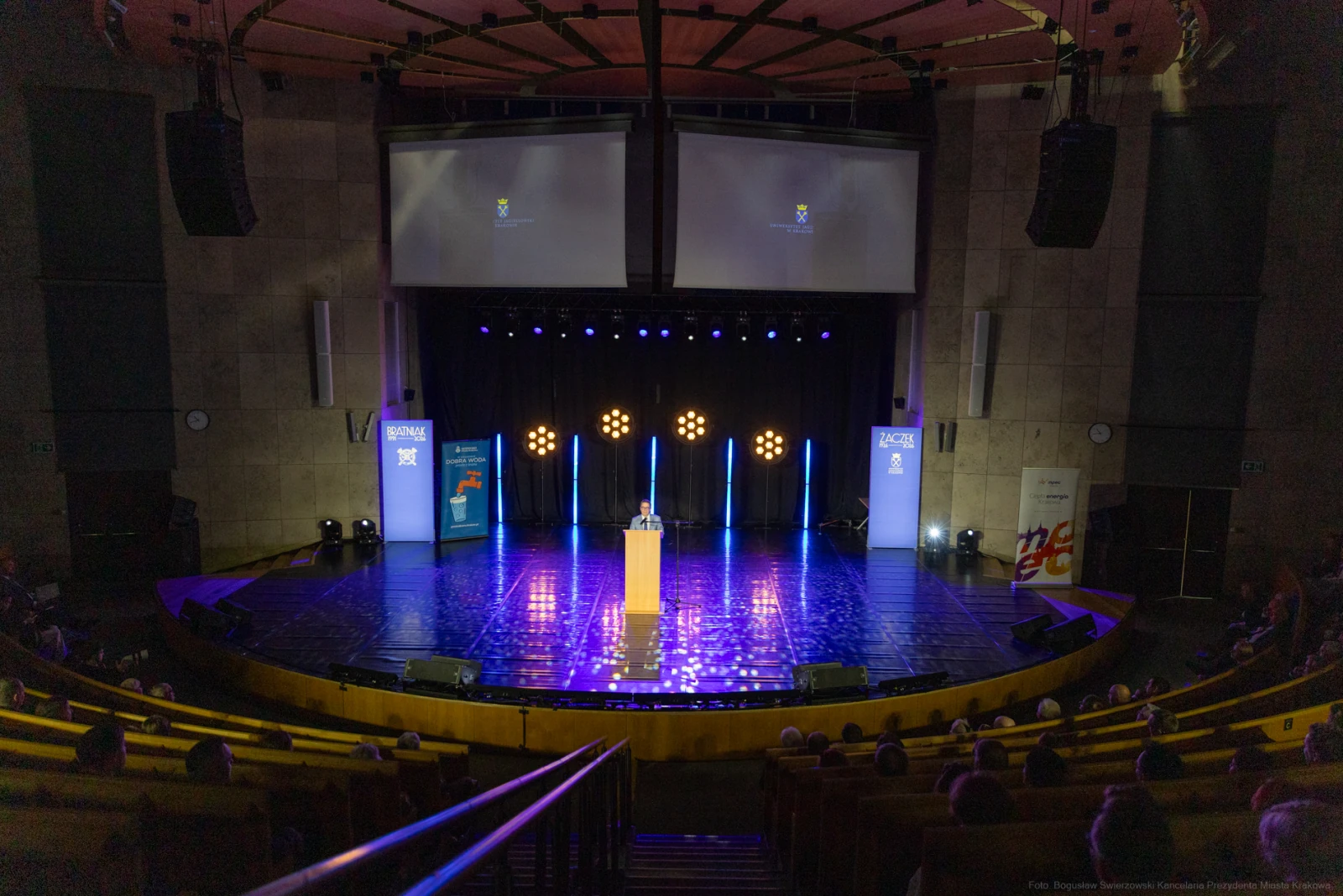 Scena z podium, oświetlona reflektorami, z widownią w tle.  Autor: Bogusław Świerzowski