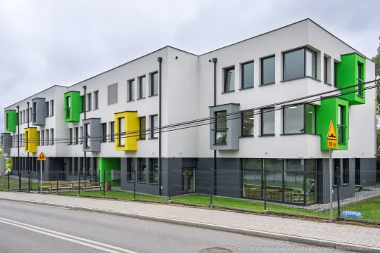 Nowoczesny budynek mieszkalny z kolorowymi akcentami w architekturze.