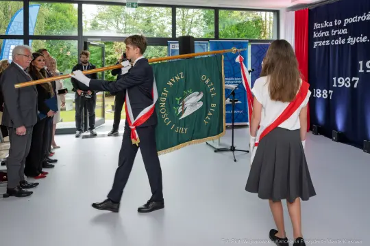 Uczniowie niosą sztandar podczas uroczystości szkolnej.