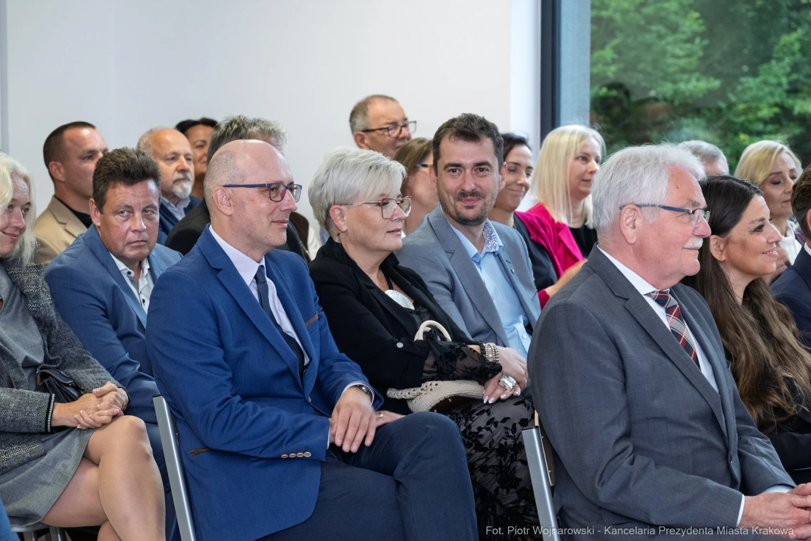 Grupa ludzi siedzących na wydarzeniu, uśmiechających się i rozmawiających.  Autor: Piotr Wojnarowski