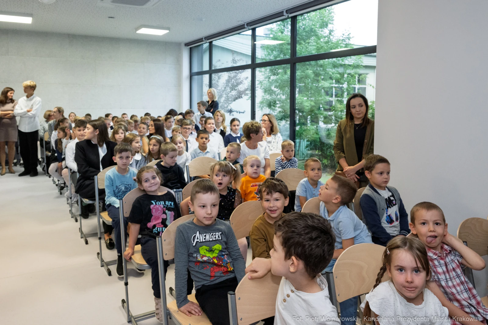 Grupa dzieci siedzących w sali, uśmiechających się i rozmawiających.  Autor: Piotr Wojnarowski