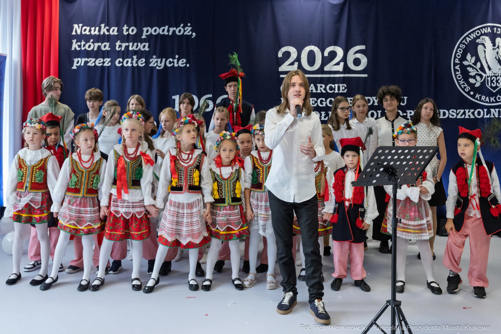 Grupa dzieci w tradycyjnych strojach ludowych występuje na scenie podczas uroczystości.  Autor: Piotr Wojnarowski