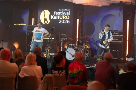 Dwaj muzycy na scenie festiwalu KultURO 2026, z instrumentami i sprzętem nagłośnieniowym.