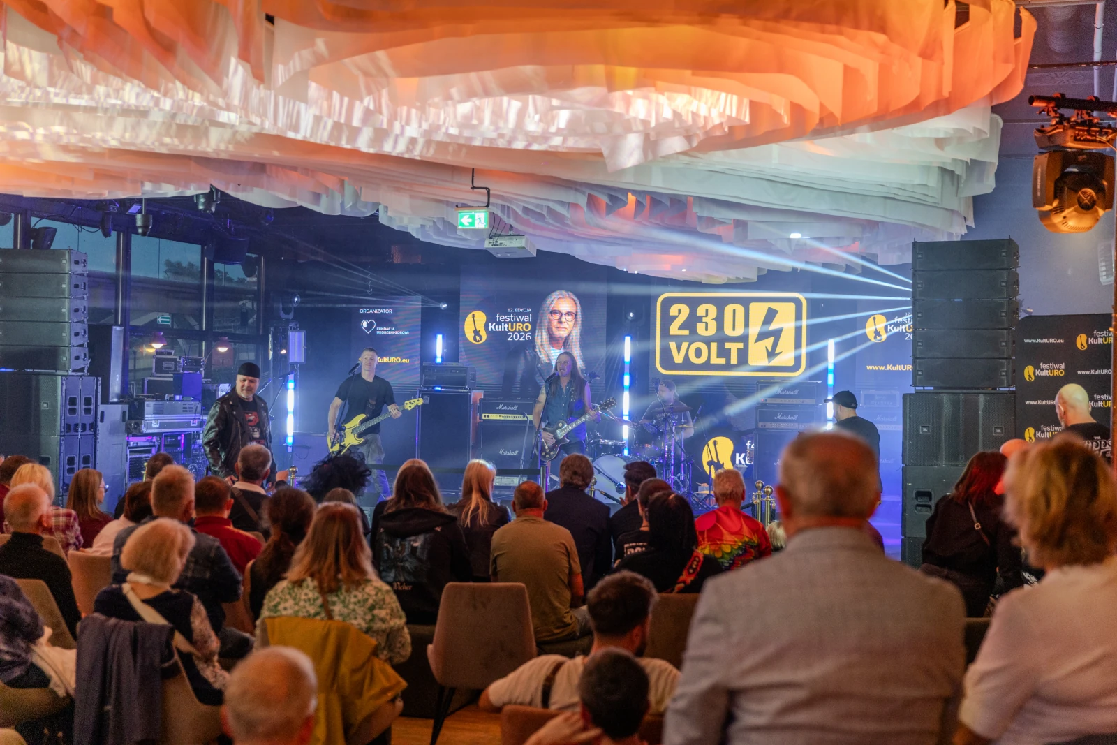 Koncert zespołu 230 Volt w nowoczesnej przestrzeni z oświetleniem i publicznością.  Autor: Bogusław Świerzowski