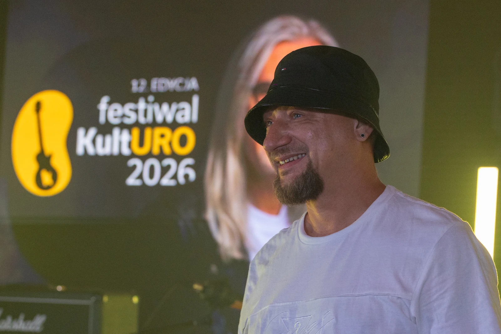 Mężczyzna w kapeluszu uśmiecha się przed tłem festiwalu KultURO 2026.  Autor: Bogusław Świerzowski