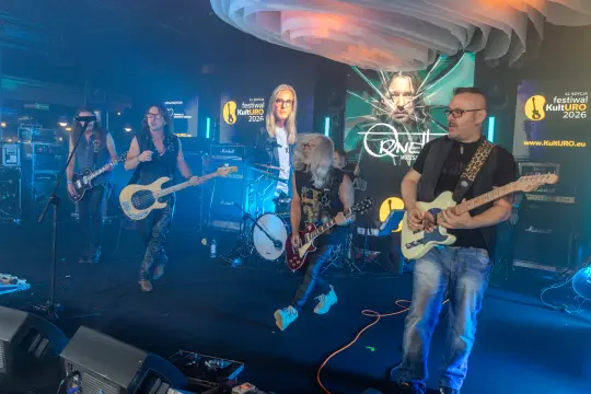 Zespół grający na festiwalu, instrumenty muzyczne, oświetlenie sceniczne.