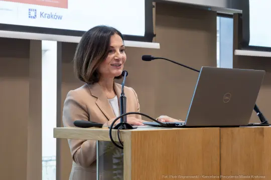 Kobieta przemawia za mównicą podczas konferencji w Krakowie.