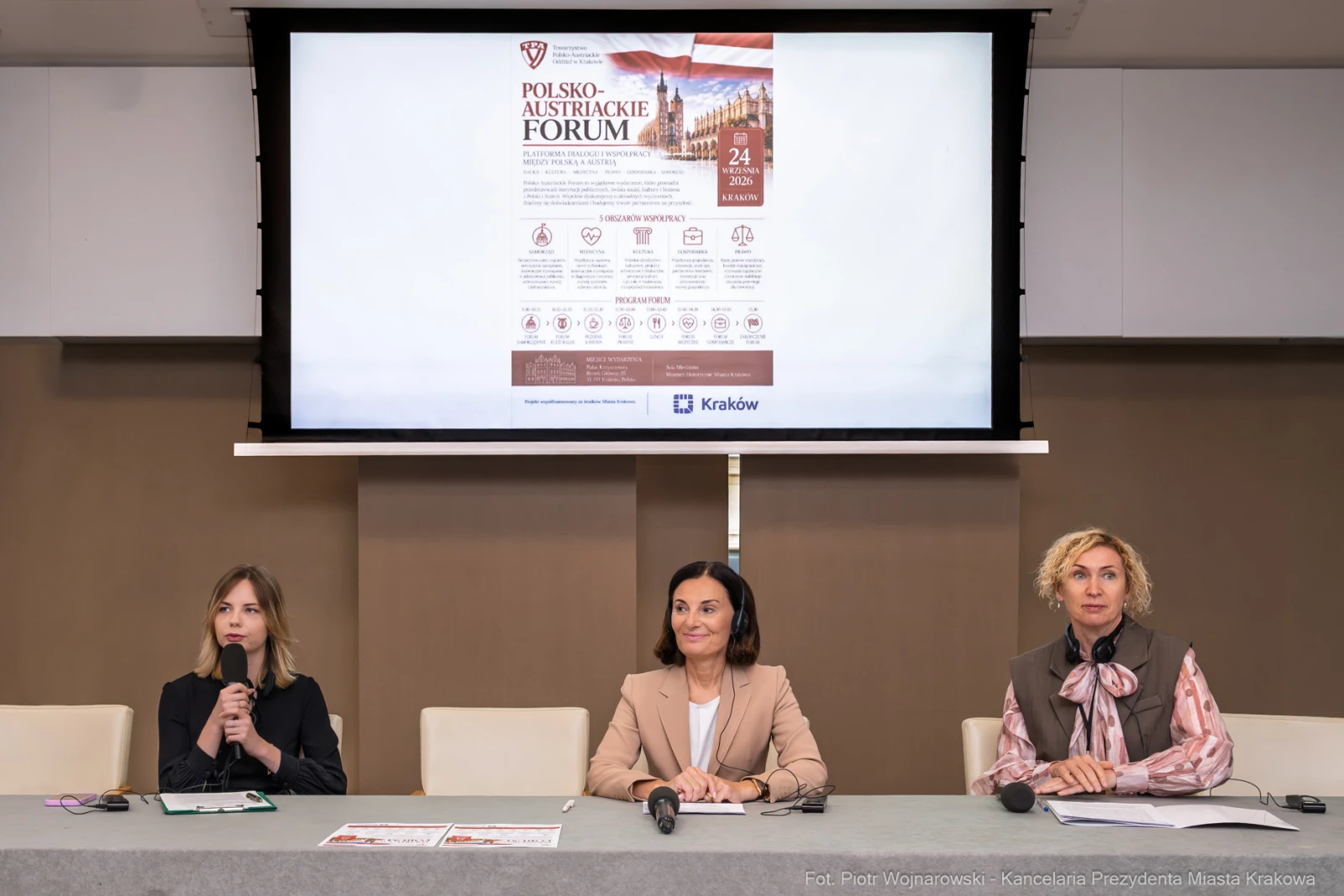 Trzy kobiety siedzą przy stole, prezentacja na ekranie dotyczy Polsko-Austriackiego Forum.  Autor: Piotr Wojnarowski