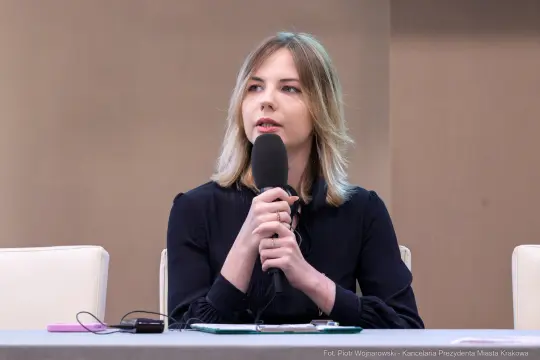 Kobieta z mikrofonem, prowadząca dyskusję na konferencji.