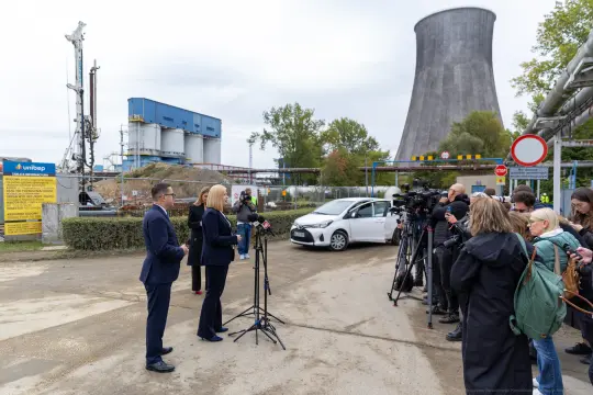 Konferencja prasowa przed elektrownią, dziennikarze i przedstawiciele mediów.