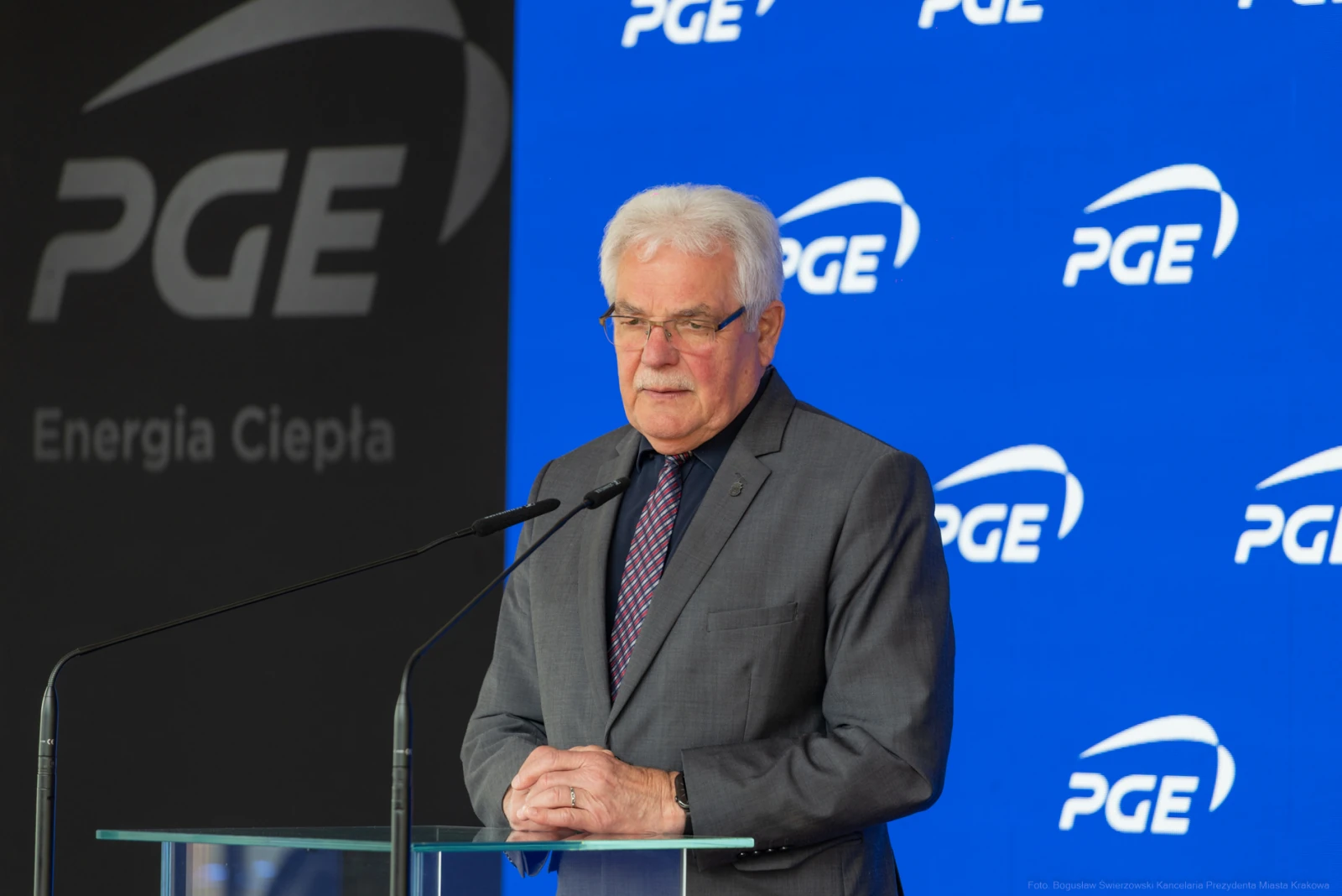 Mężczyzna w garniturze przemawia przy mównicy z logo PGE w tle.  Autor: Bogusław Świerzowski