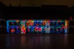 Kolorowe iluminacje na elewacji budynku z architekturą renesansową.