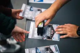 Osoba stempluje ulotki w punkcie informacyjnym.