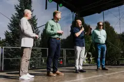 Czterech mężczyzn na scenie, jeden z nich mówi do mikrofonu.