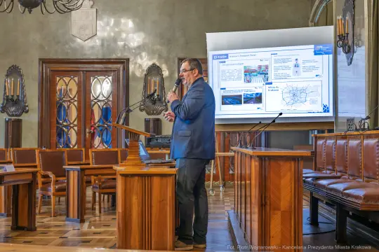 Mężczyzna prezentujący slajdy na konferencji w sali obrad.