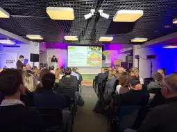 Prezentacja na konferencji z widownią w sali wykładowej.