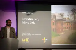 Mężczyzna przy mównicy prezentuje temat dziedzictwa w Fortach Jugowice.