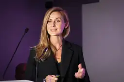 Kobieta w czarnym garniturze prezentuje na konferencji.