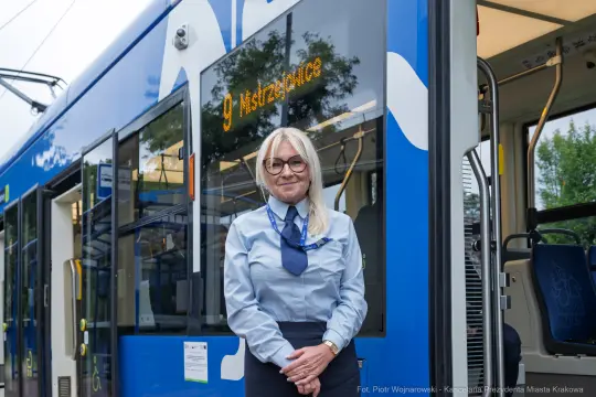 Kobieta w uniformie stoi obok tramwaju w Krakowie. Na wyświetlaczu numer linii.