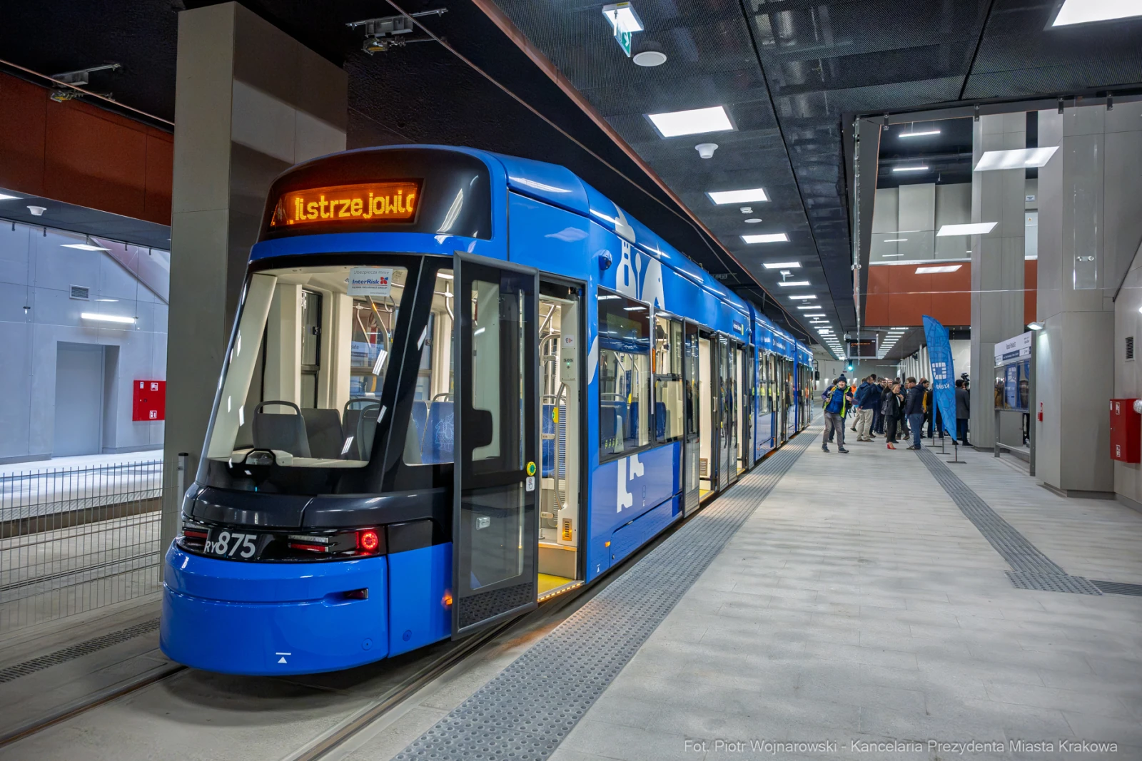 Nowoczesny tramwaj w stacji, z pasażerami i informacjami o trasie.  Autor: Piotr Wojnarowski