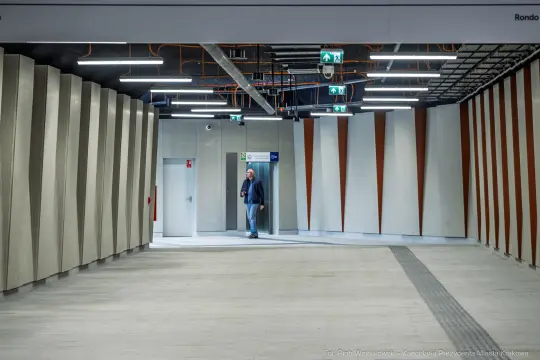 Pusty korytarz w nowoczesnym budynku z mężczyzną przy drzwiach.