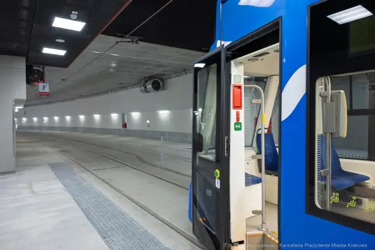 Nowoczesny tramwaj w tunelu, z widokiem na peron i torowisko.