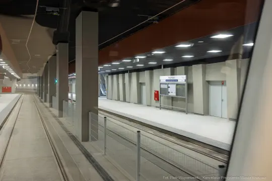 Nowoczesna stacja metra z pustymi peronami i oświetleniem.