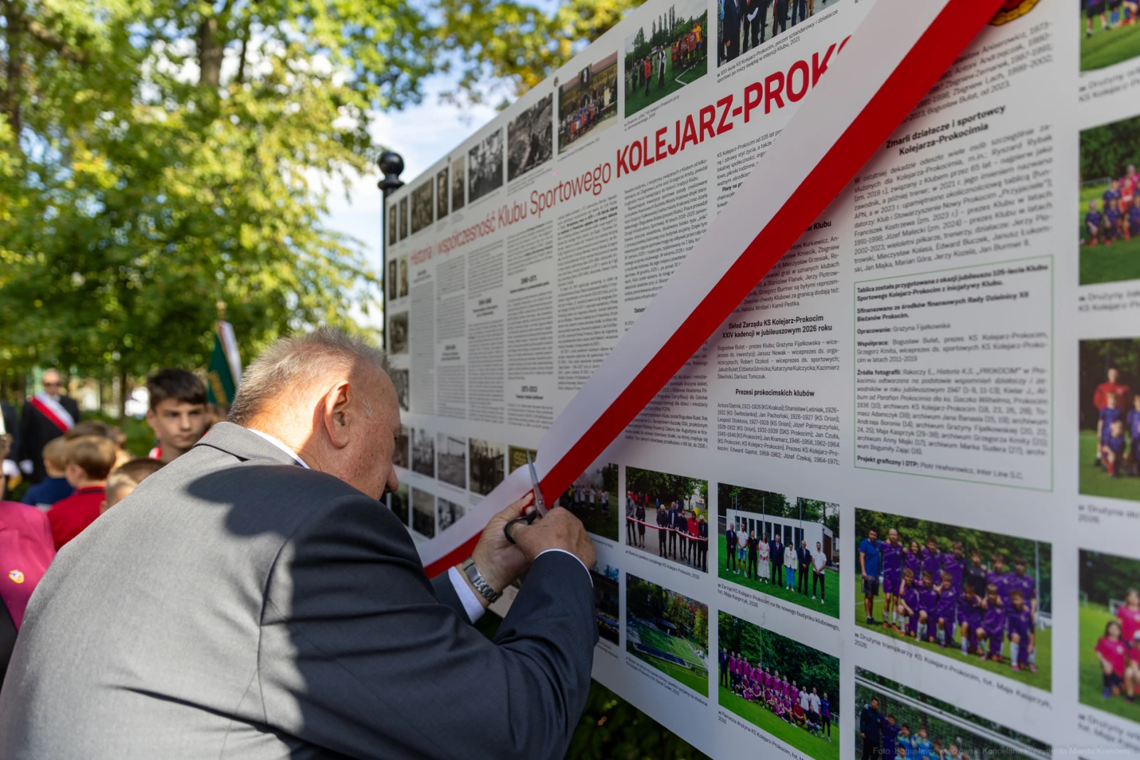 Mężczyzna podpisuje tablicę z informacjami o Klubie Sportowym Kolejarz-Prokocim.  Autor: Bogusław Świerzowski