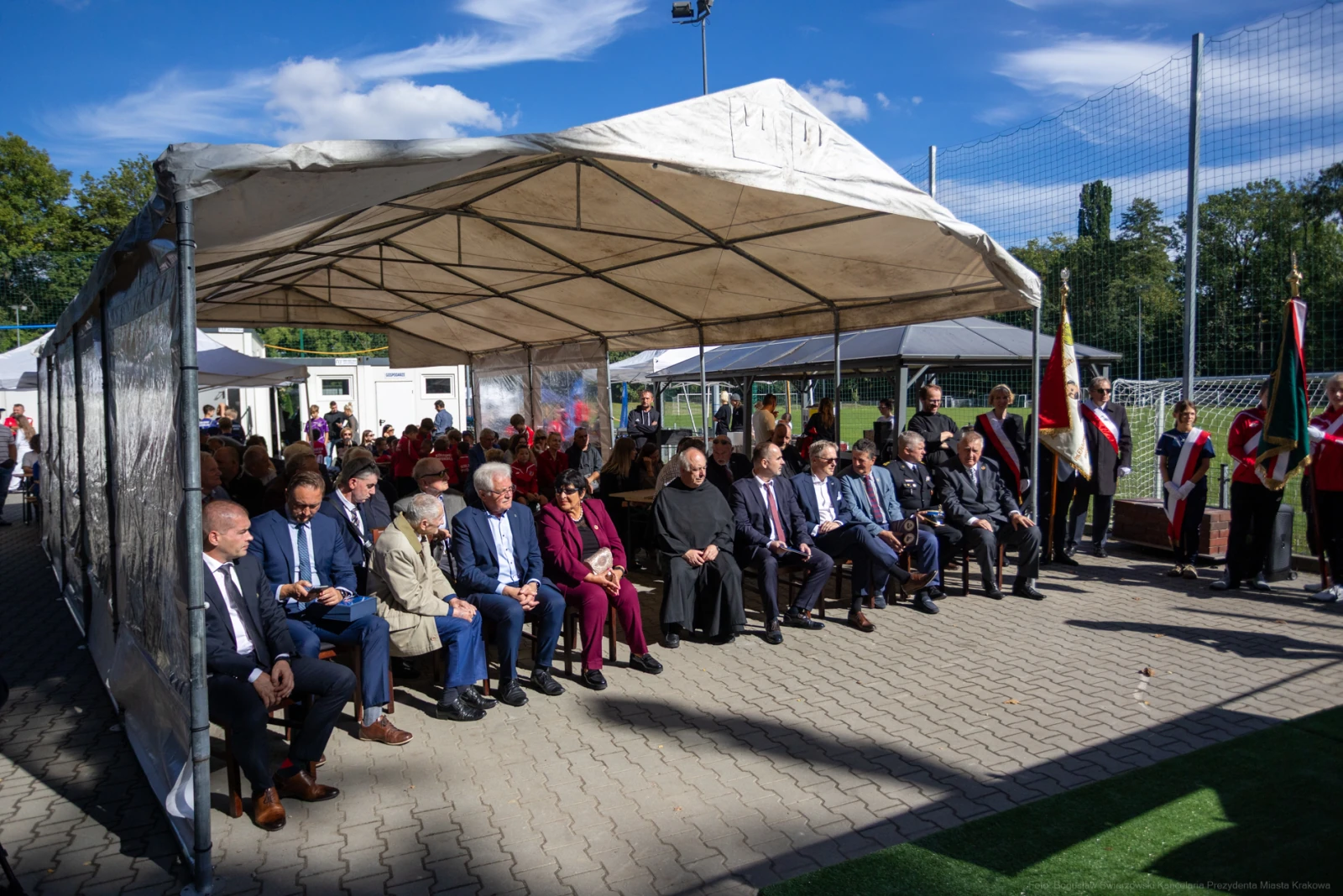 Grupa osób siedzących pod namiotem na wydarzeniu plenerowym.  Autor: Bogusław Świerzowski