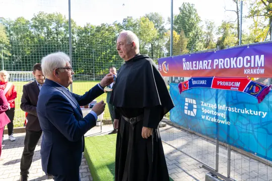 Ceremonia wręczenia odznaczenia na boisku sportowym w Krakowie.