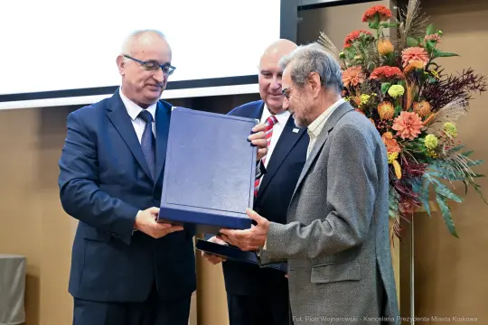 Trzech mężczyzn podczas wręczenia nagrody lub wyróżnienia.