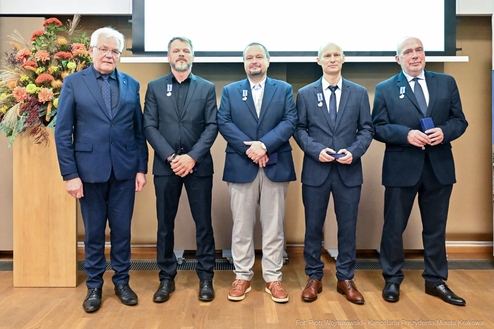 Uroczystość wręczenia odznaczeń, pięciu mężczyzn w garniturach z medalami.  Autor: Piotr Wojnarowski