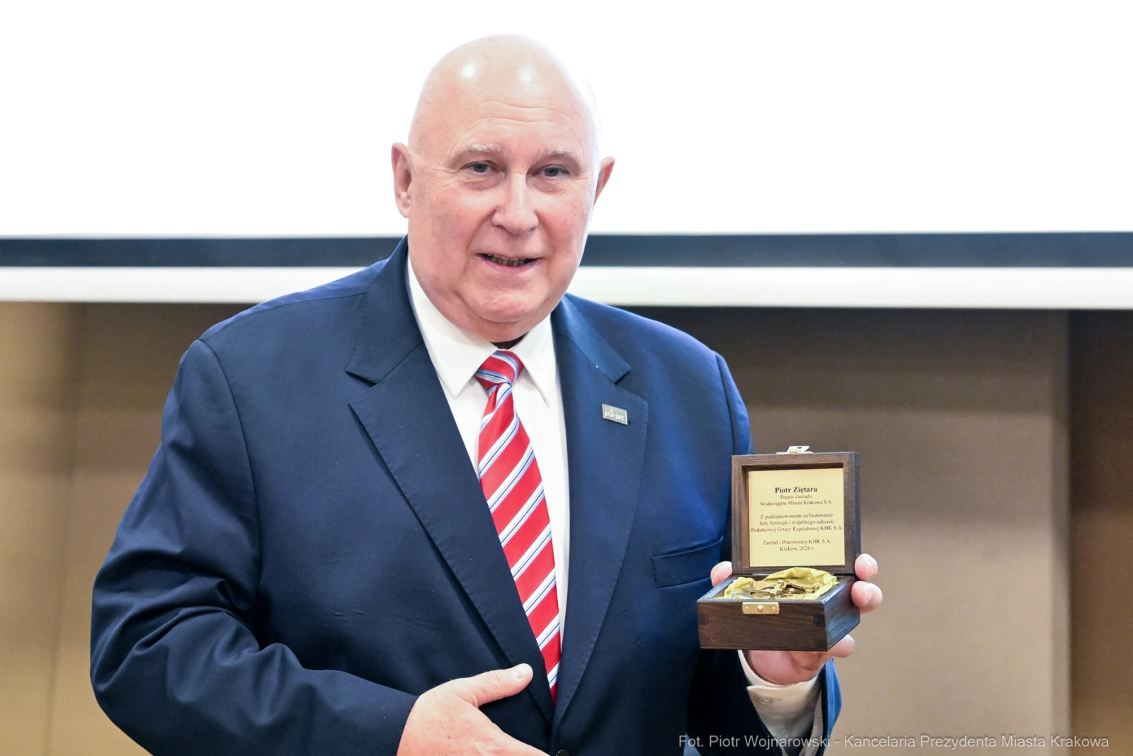 Mężczyzna w garniturze trzyma medal w eleganckim pudełku.  Autor: Piotr Wojnarowski