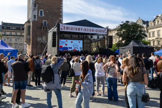Tłum ludzi na wydarzeniu z okazji Światowego Dnia Serca. Scena z wystąpieniami i stoiska informacyjne.