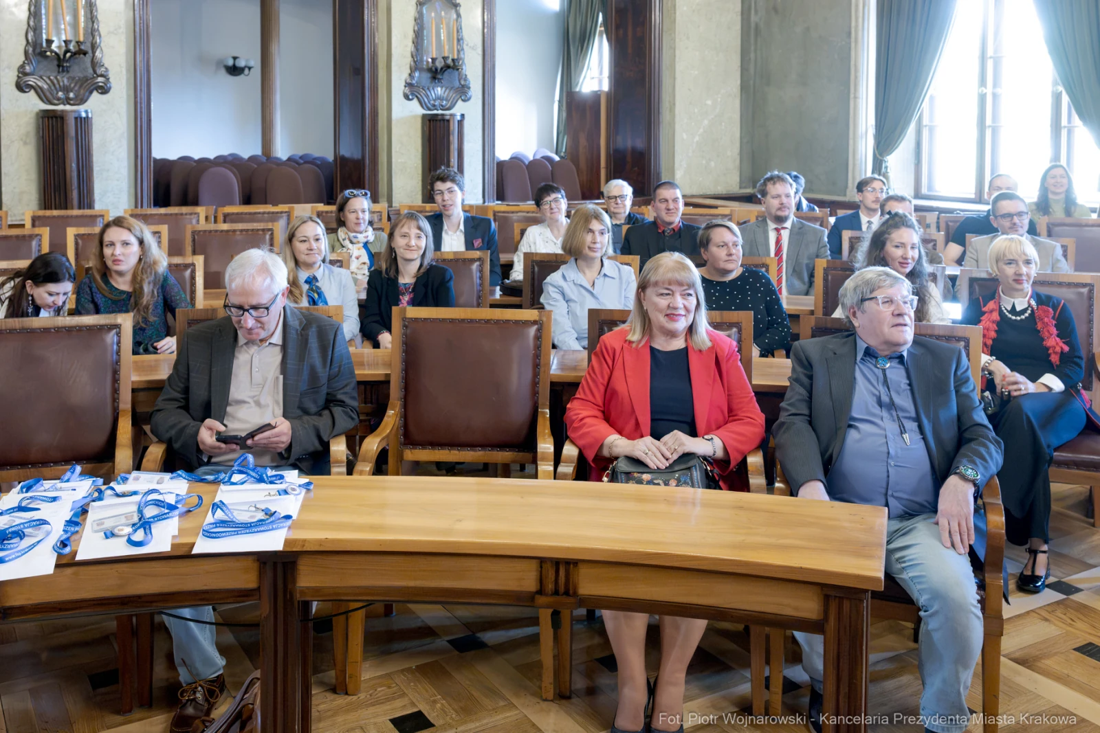 Grupa ludzi siedzących w sali konferencyjnej, część z nich korzysta z telefonów.  Autor: Piotr Wojnarowski
