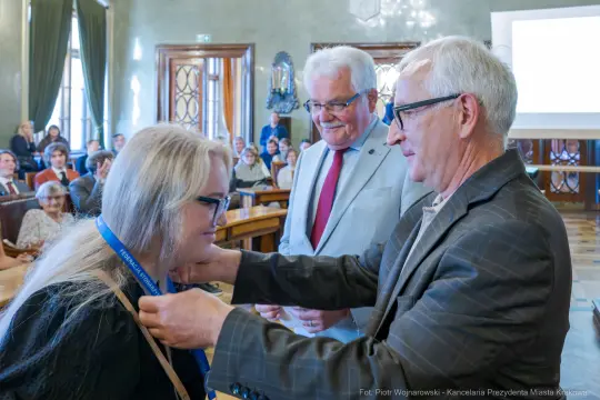Wręczenie medalu honorowego podczas uroczystości w sali miejskiej.
