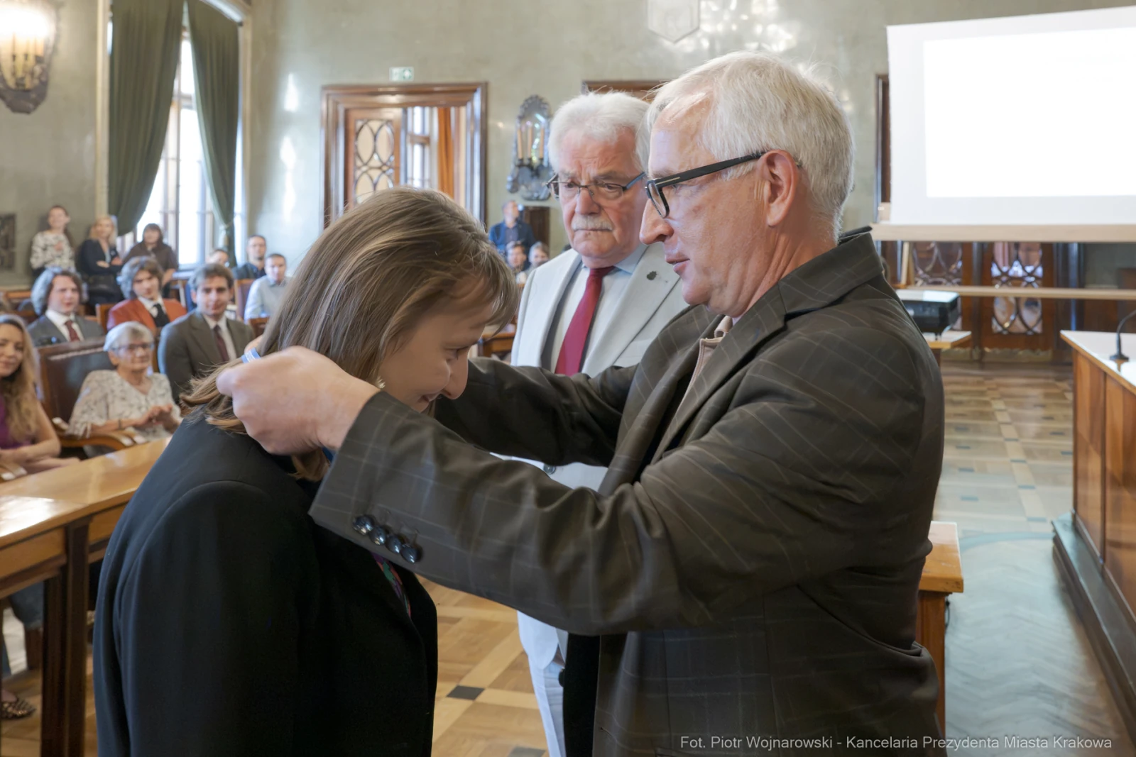 Uroczystość wręczenia odznaczenia w sali obrad z obecnością gości.  Autor: Piotr Wojnarowski