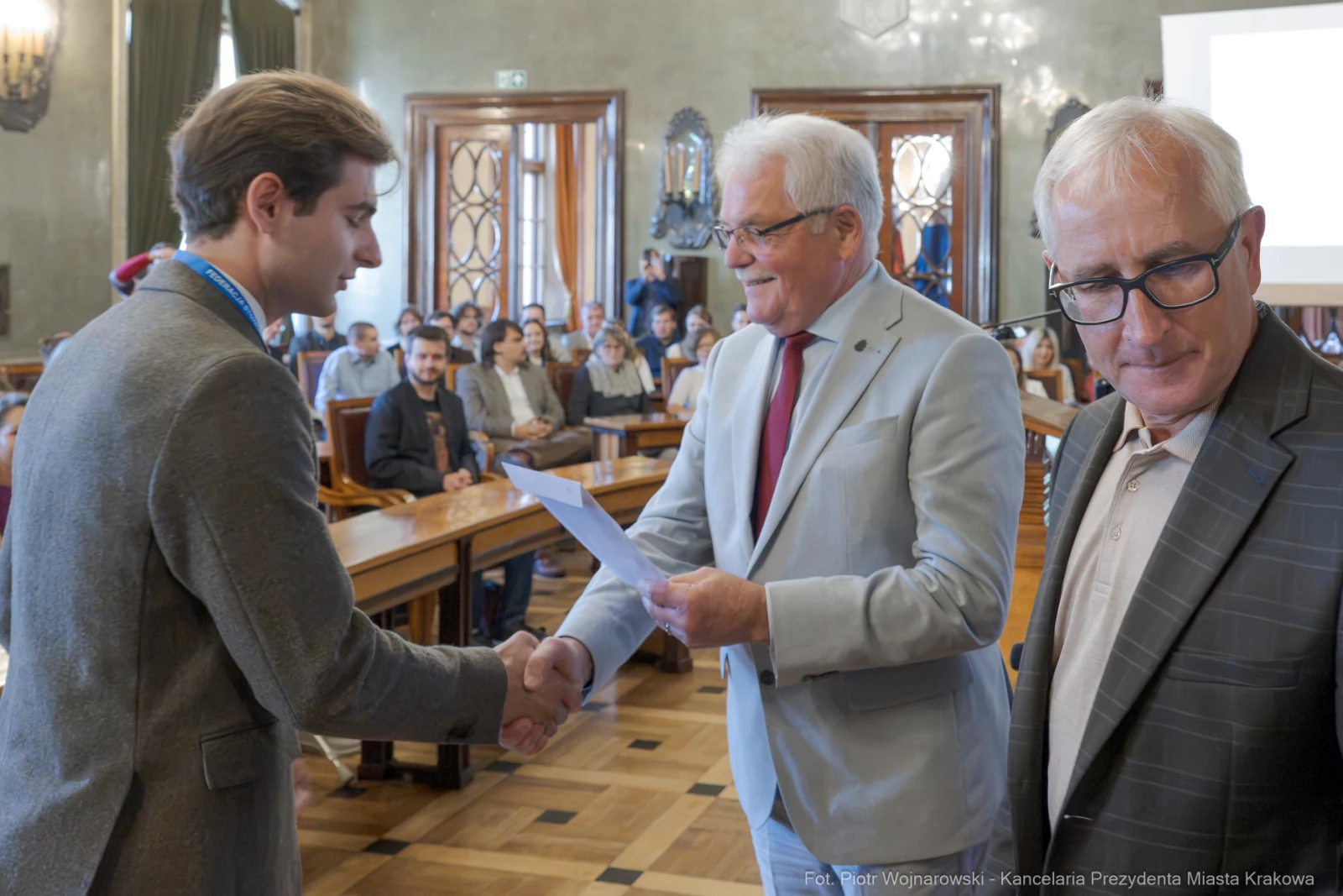 Uroczystość wręczenia nagrody w sali obrad z uśmiechniętymi uczestnikami.  Autor: Piotr Wojnarowski