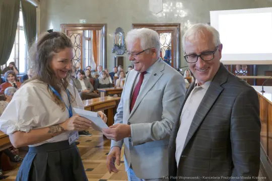 Wręczenie nagrody przez przedstawicieli miasta. Uśmiechnięte twarze uczestników.