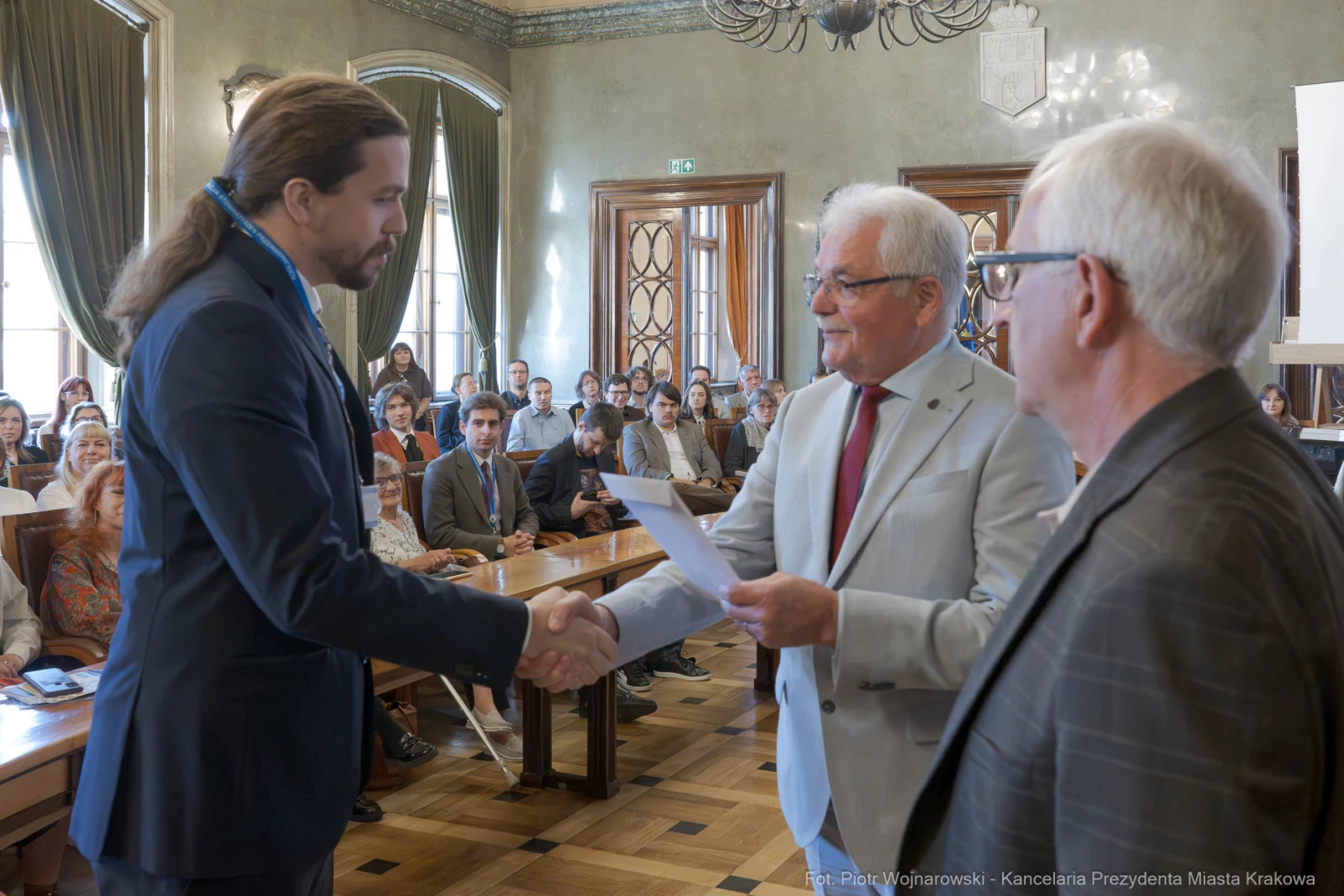 Wręczenie dyplomów w sali konferencyjnej, uściski dłoni i gratulacje.  Autor: Piotr Wojnarowski