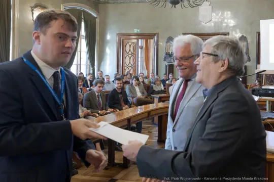 Wręczenie dyplomu podczas uroczystości w sali obrad.