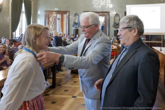 Wręczenie medalu podczas uroczystości w sali obrad.