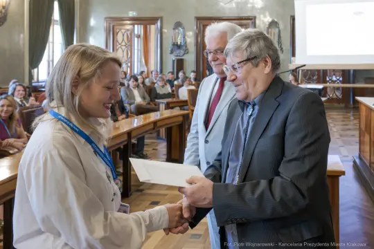 Wręczenie dyplomu podczas uroczystości w sali obrad.
