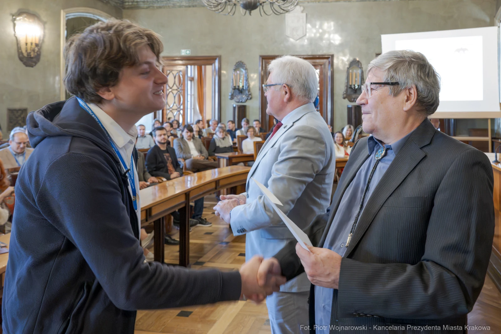 Uroczystość wręczenia nagród, uściski dłoni i gratulacje w sali konferencyjnej.  Autor: Piotr Wojnarowski
