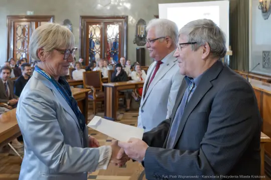 Wręczenie dyplomu podczas uroczystości w sali obrad.