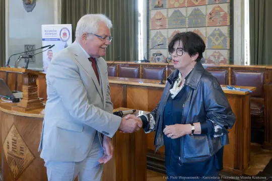 Spotkanie dwóch osób, uścisk dłoni w sali konferencyjnej.
