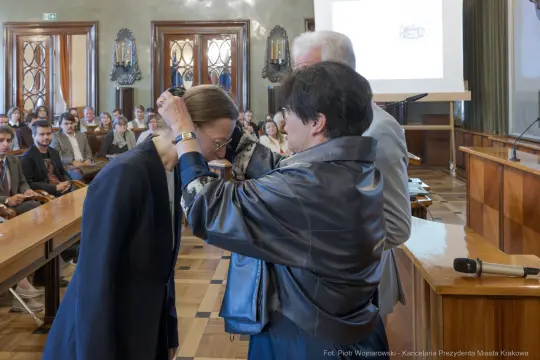 Wręczenie odznaczenia podczas ceremonii w sali obrad.