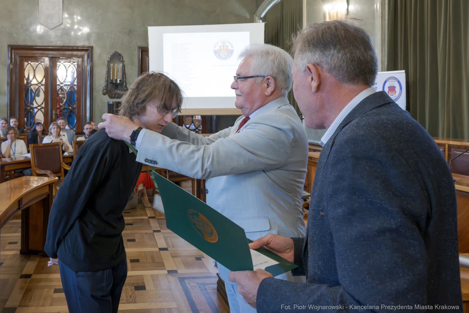 Wręczenie dyplomu młodemu laureatowi w sali obrad.  Autor: Piotr Wojnarowski