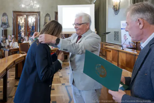 Wręczenie odznaczenia podczas uroczystości w sali obrad.