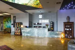 Nowoczesna recepcja hotelowa z marmurowym blatem i dekoracyjnymi elementami.